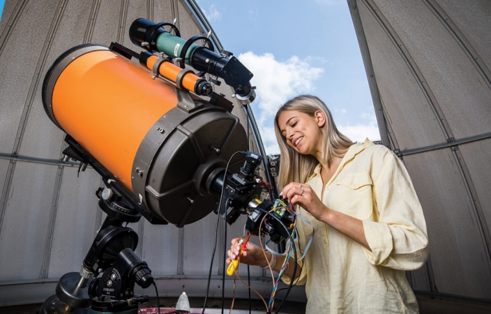  a girl fixing a telescope